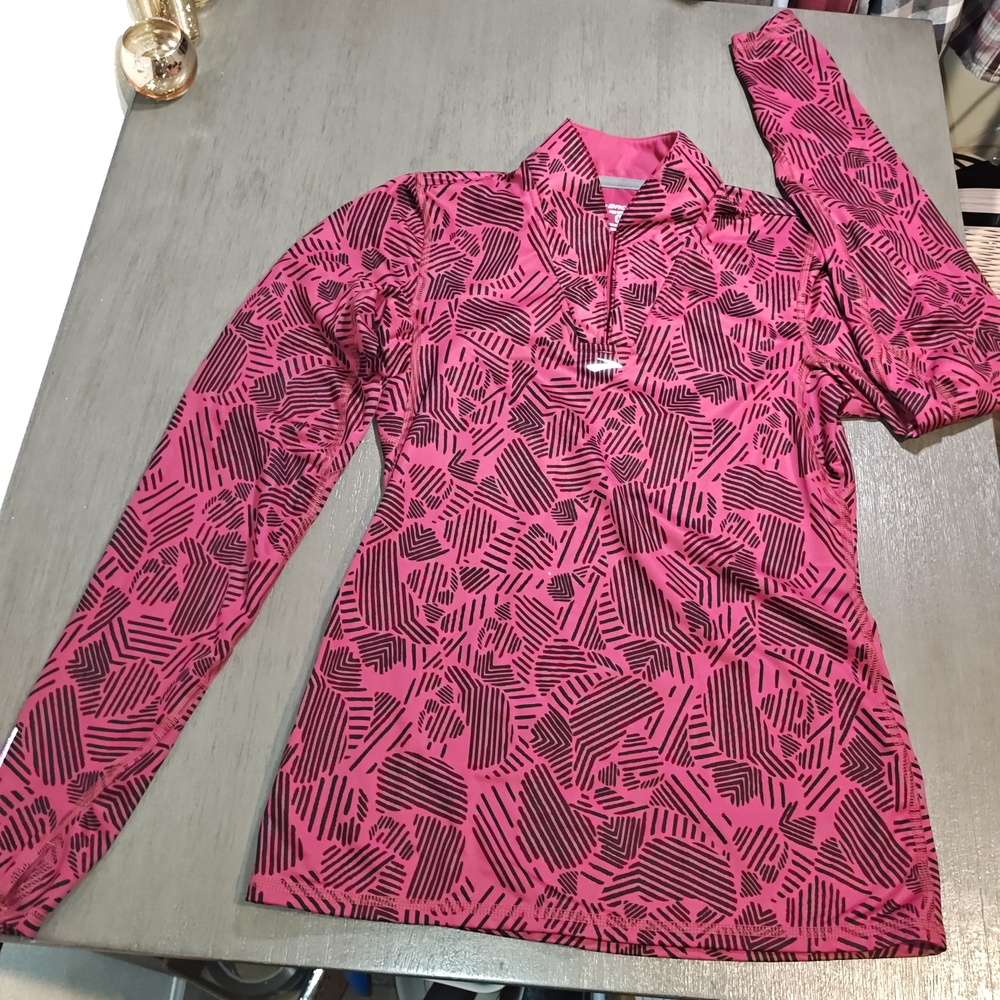 Brooks brand Woman's long-sleeve performance running top featuring a pink and...
